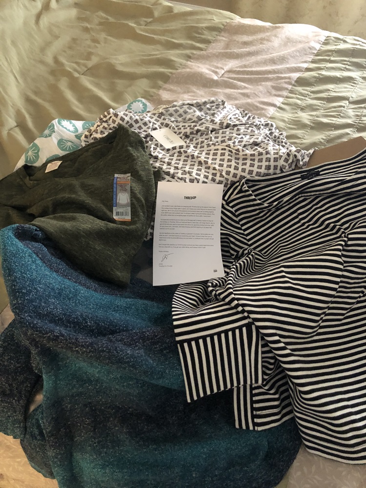 Image of 4 long-sleeved women's plus size tops displayed on top of ThredUp box with enclosed note from ThreadUp: 1) black and white striped top, 2) a sparkley multihued blue sweater, 3) and olive raglan sweater top with tag still on, 4) a diamond patterened white and gray top with tag still on.